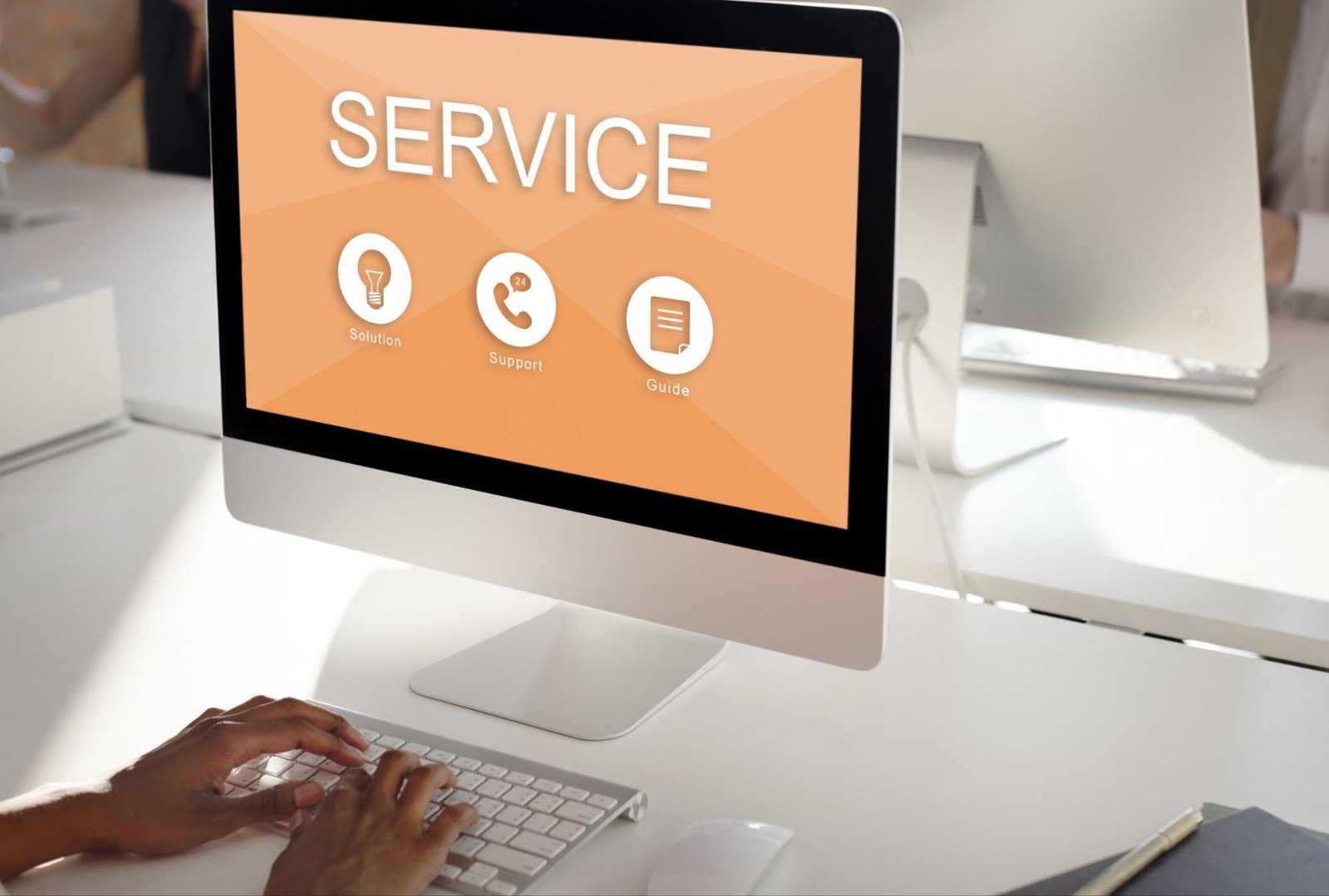 Person working on desktop computer displaying service options for solution support and guide, representing ecommerce maintenance and support retainer.