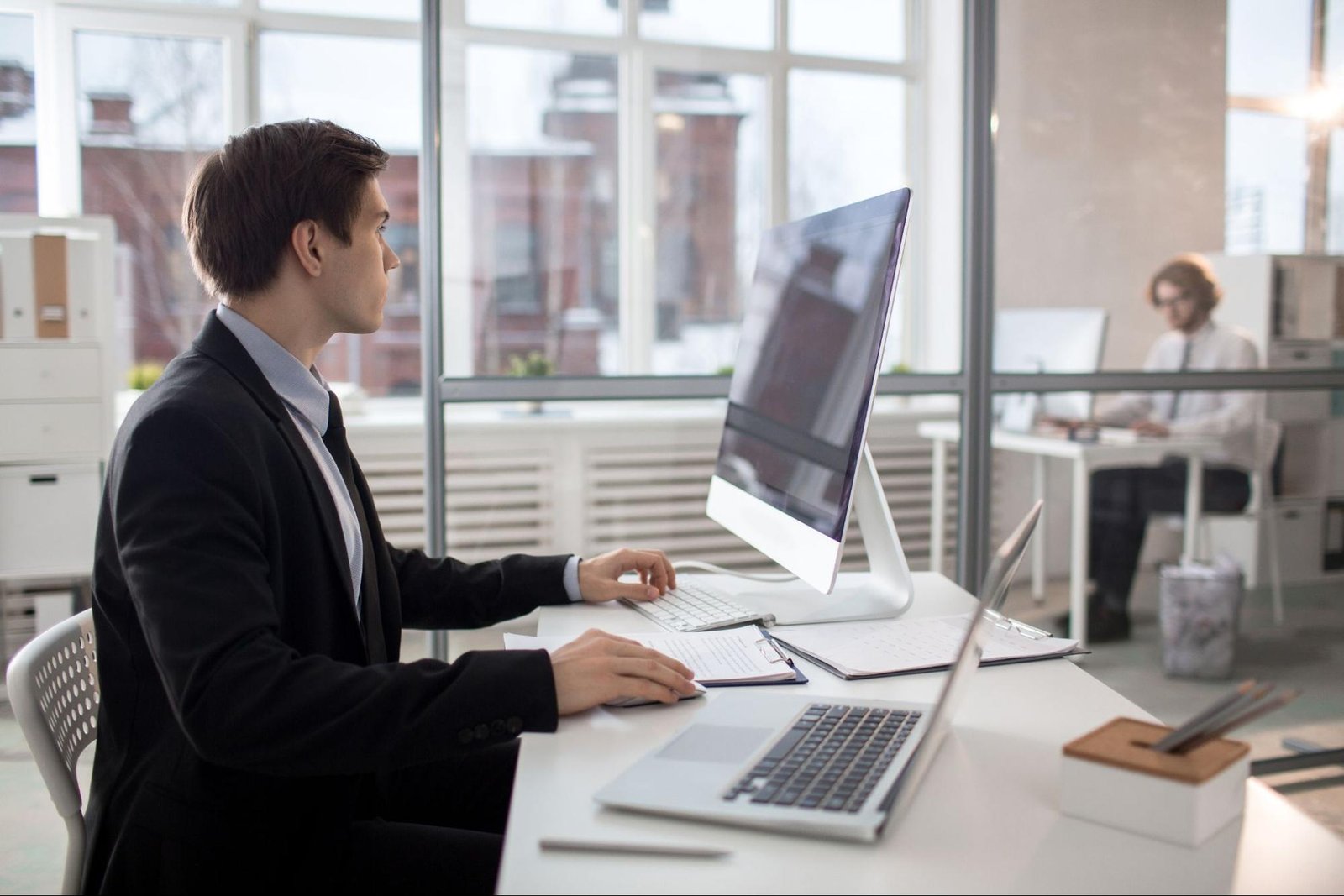 Business professionals working on desktop computers representing enterprise level ecommerce development.